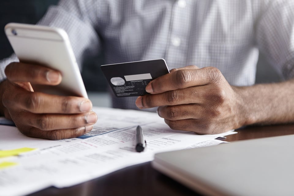 african-man-shirt-paying-goods-internet-using-credit-card-cell-phone